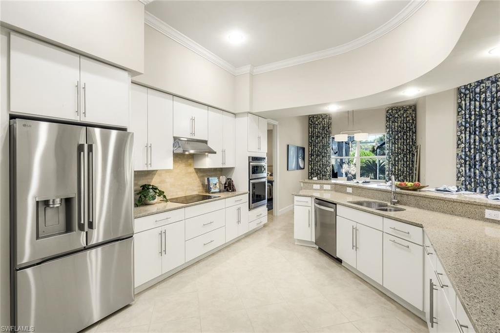9314 Quarry Drive Naples, FL 34120 - Photo 15 of 49 a kitchen with white cabinets and stainless steel appliances