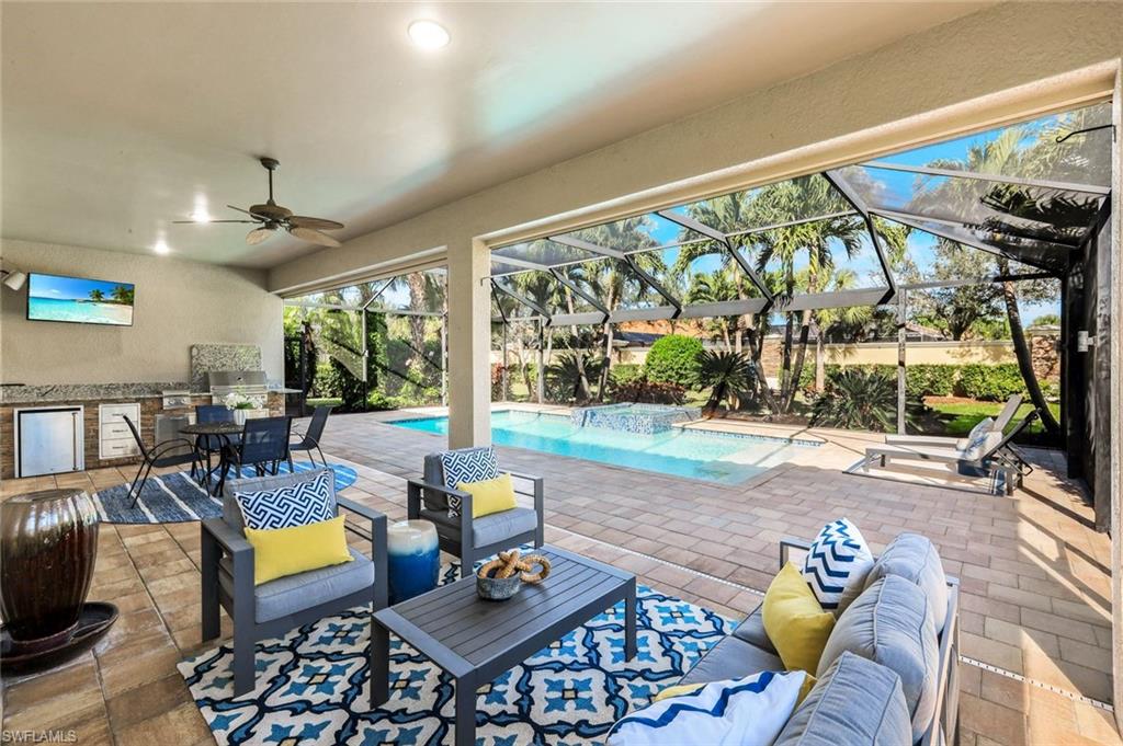 9314 Quarry Drive Naples, FL 34120 - Photo 29 of 49 a living room with furniture and a floor to ceiling window