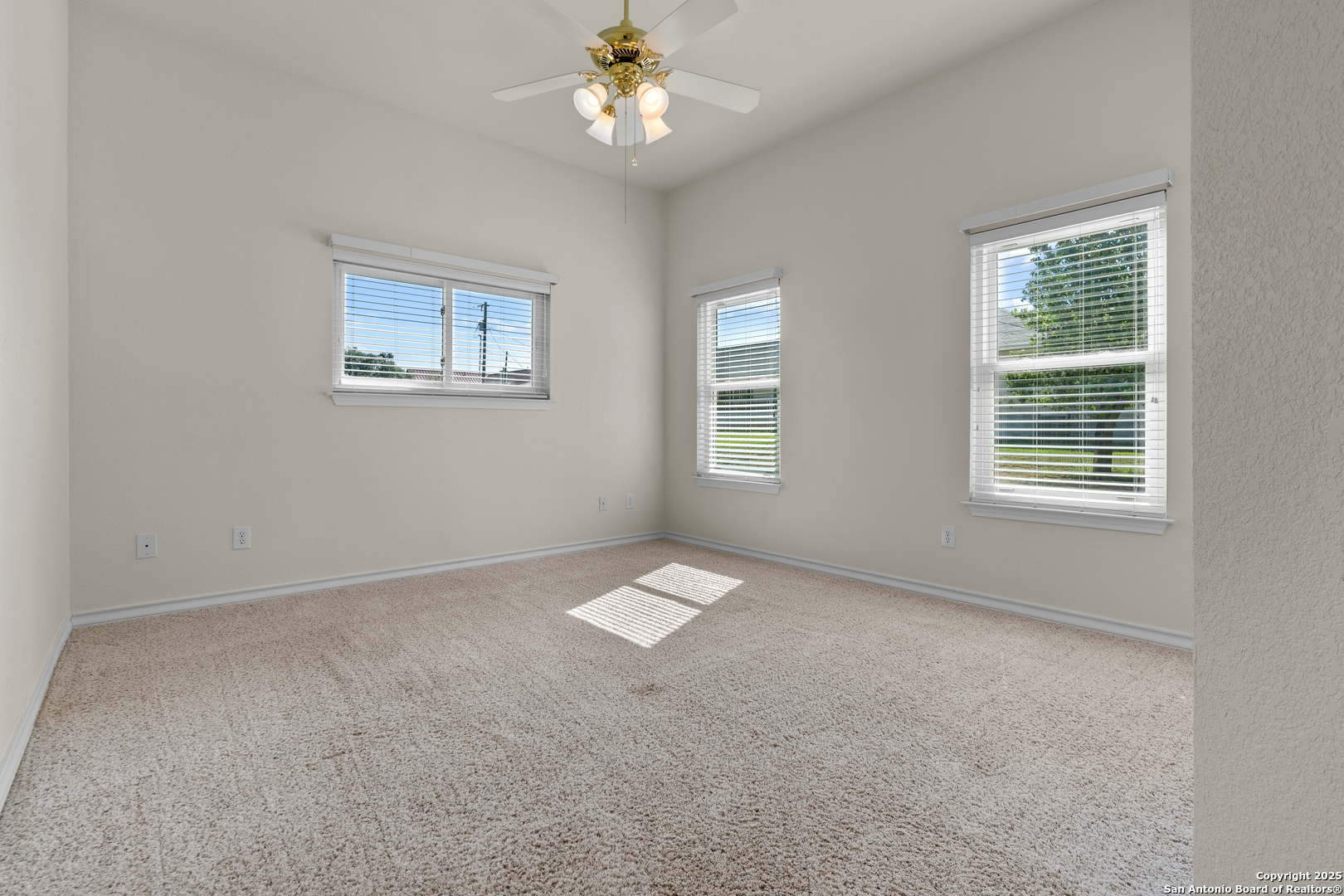 174 Edgewood Circle Bandera, TX 78003 - Photo 11 of 33 an empty room with windows and chandelier fan