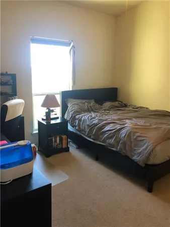 a bed sitting in a bedroom next to a window