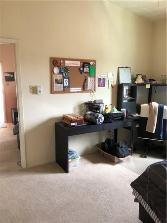 a bedroom with a bed and a refrigerator