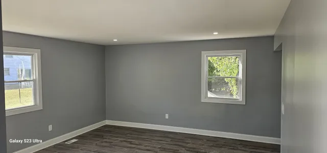 an empty room with wooden floor and a window