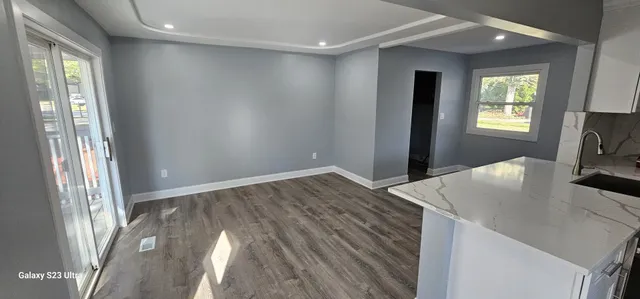 a kitchen with a wooden floor and a window