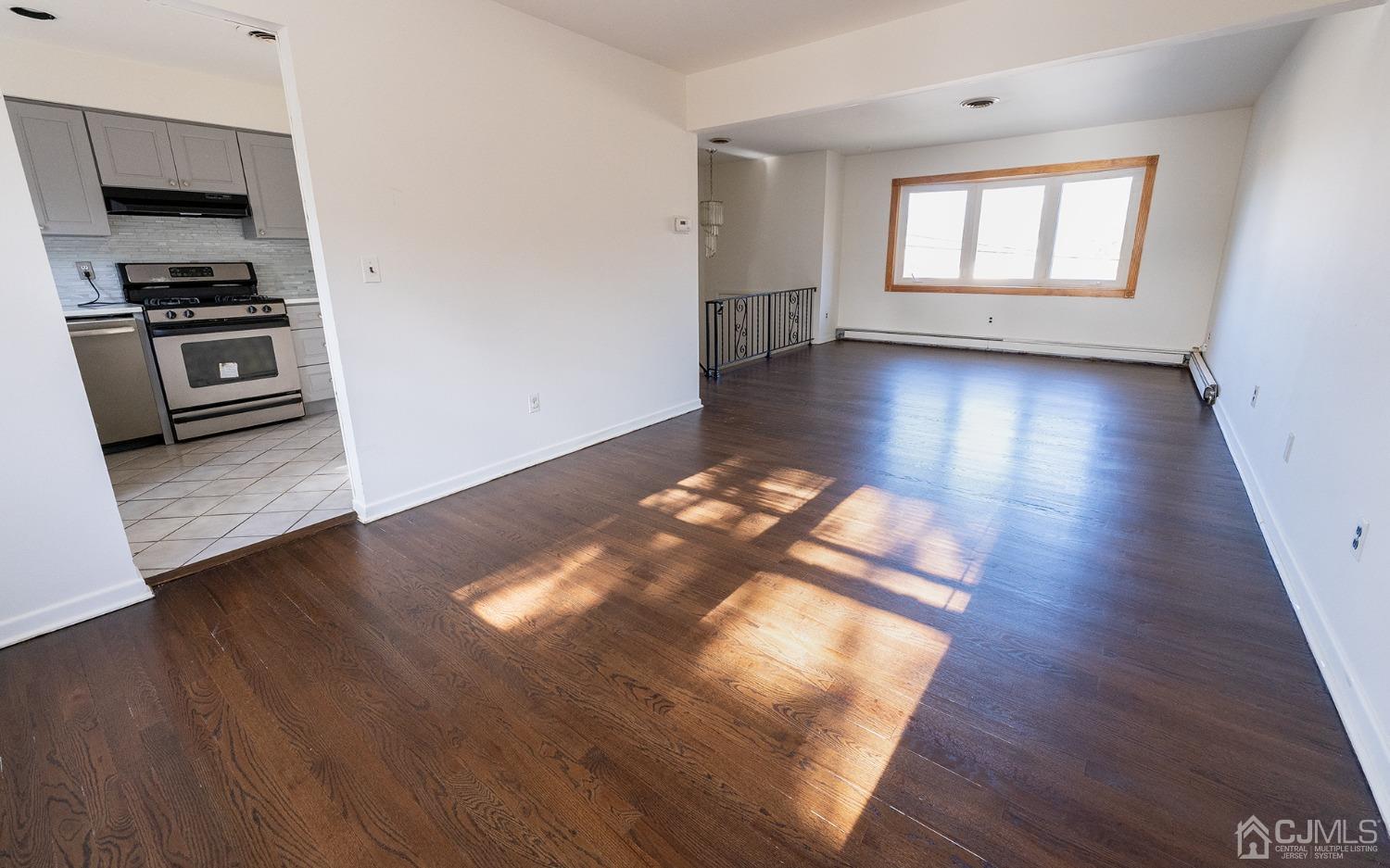 103 Alfred Street Edison, NJ 08820 - Photo 11 of 21 an empty room with wooden floor cabinets and windows