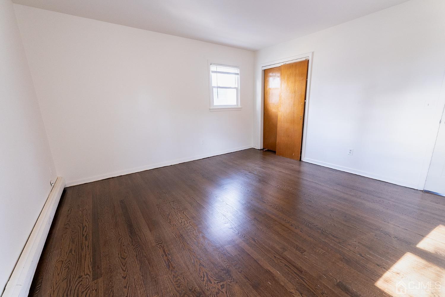 103 Alfred Street Edison, NJ 08820 - Photo 7 of 21 an empty room with wooden floor and windows