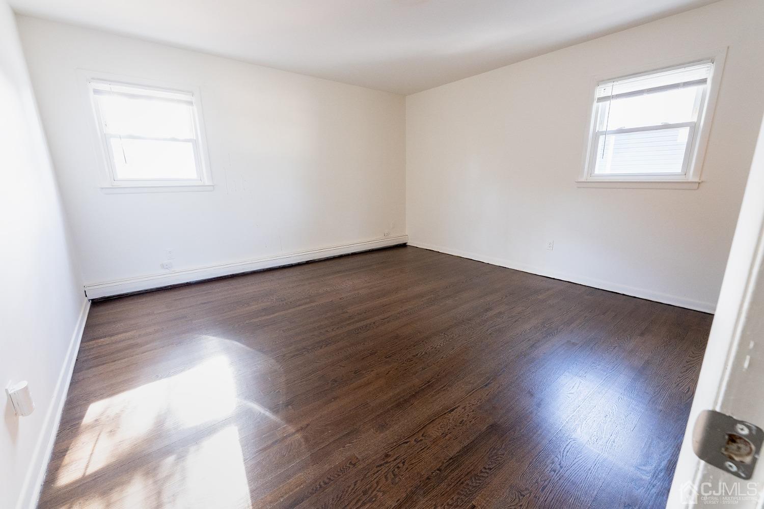 103 Alfred Street Edison, NJ 08820 - Photo 8 of 21 an empty room with wooden floor and windows