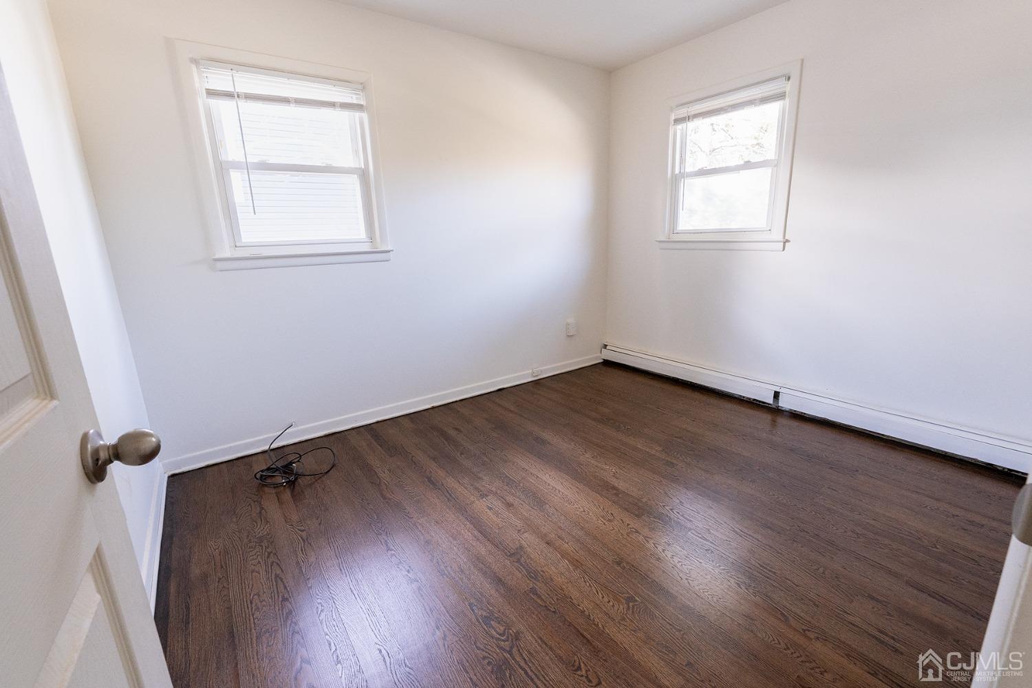 103 Alfred Street Edison, NJ 08820 - Photo 9 of 21 an empty room with wooden floor and windows