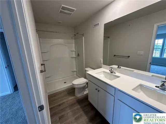 a bathroom with a sink a toilet and shower