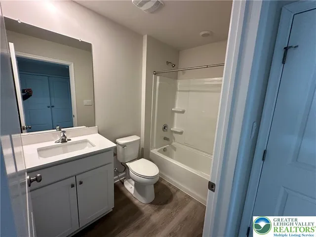a bathroom with a sink a toilet a mirror and shower