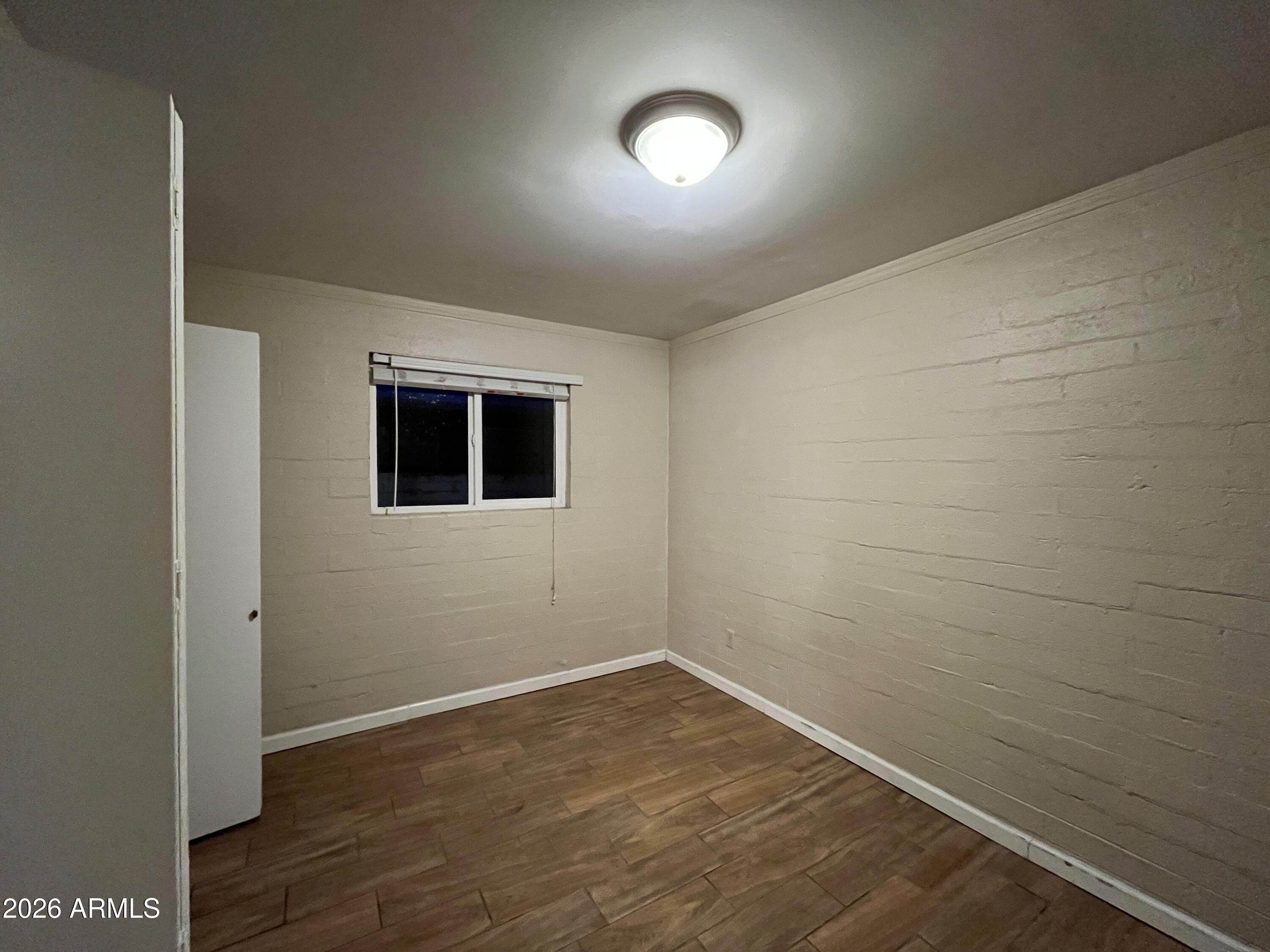 521 West 10th Street, Unit 4 Tempe, AZ 85281 - Photo 11 of 11 a view of an empty room with wooden floor and a window