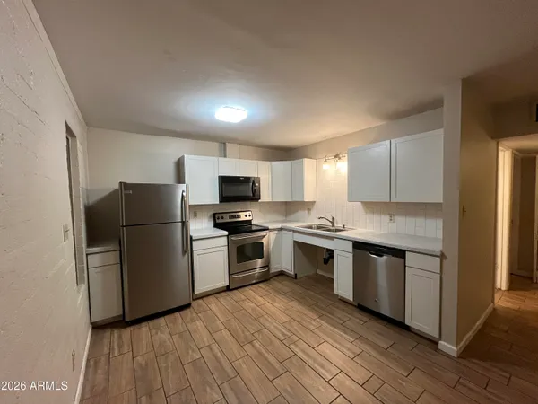 a kitchen with a sink cabinets stainless steel appliances and a window