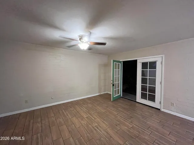 an empty room with wooden floor and window