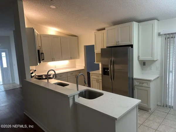 a kitchen with refrigerator cabinets and wooden floor