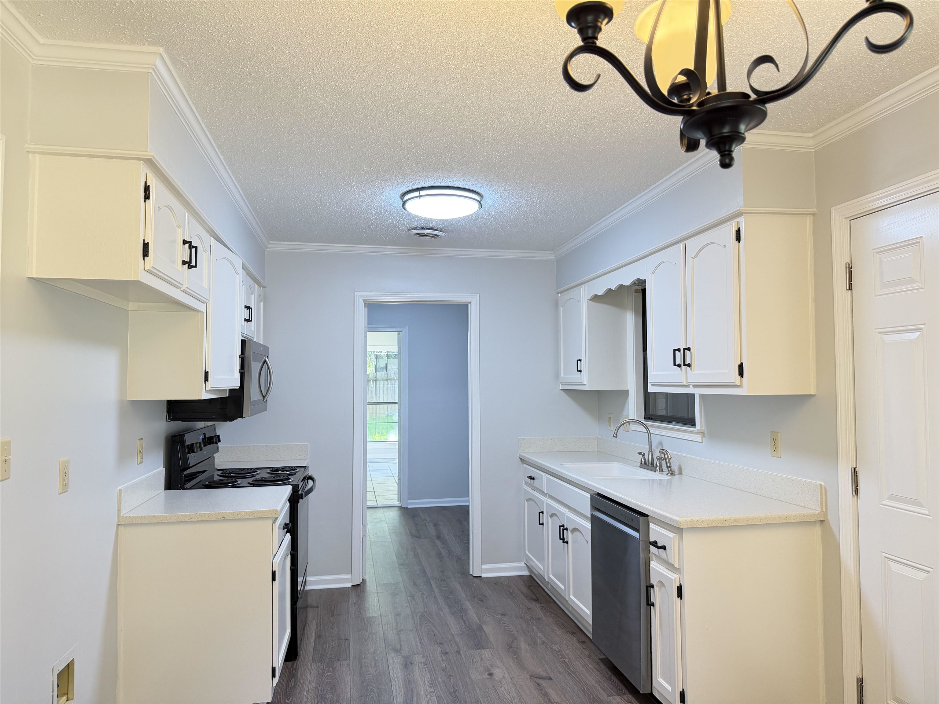 388 Park Hill Road Collierville, TN 38017 - Photo 2 of 19 Kitchen featuring white cabinetry, light countertops, wood-finish flooring, and crown molding