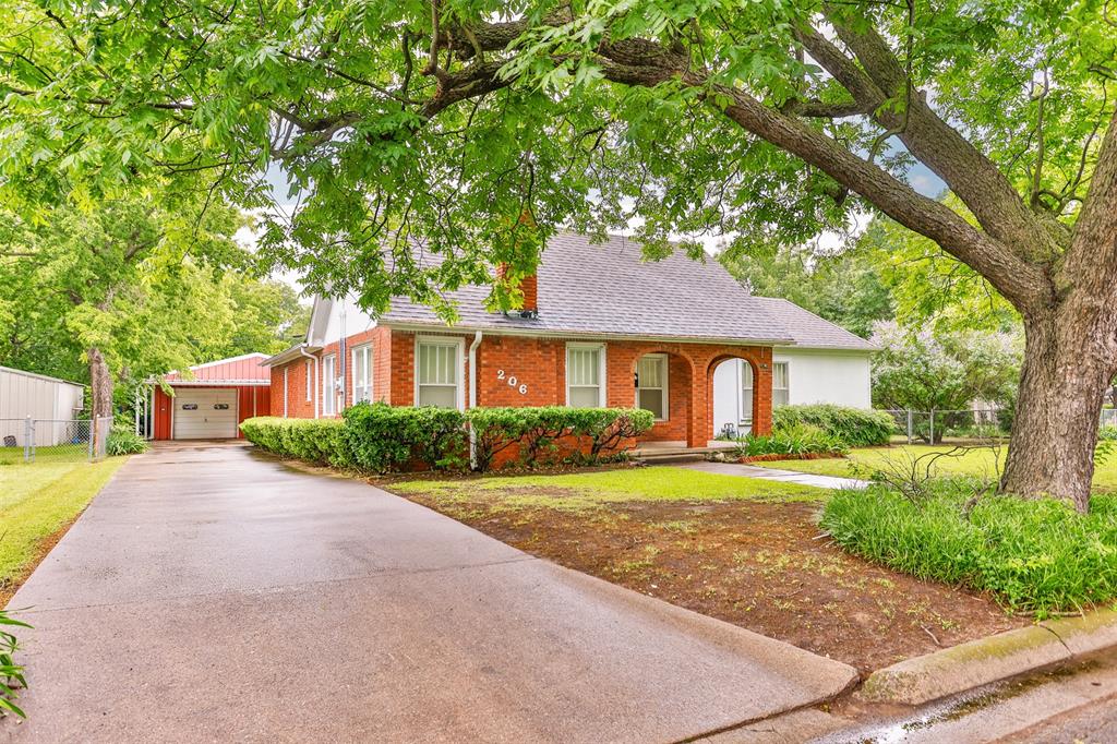 206 Ritchey Street Gainesville, TX 76240 - Photo 2 of 36 a front view of a house with a yard and trees