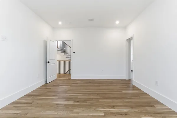 a view of empty room with wooden floor