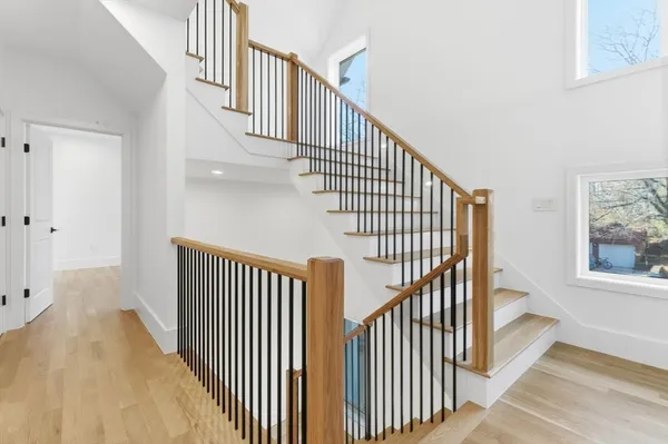 a view of staircase with wooden floor and white walls