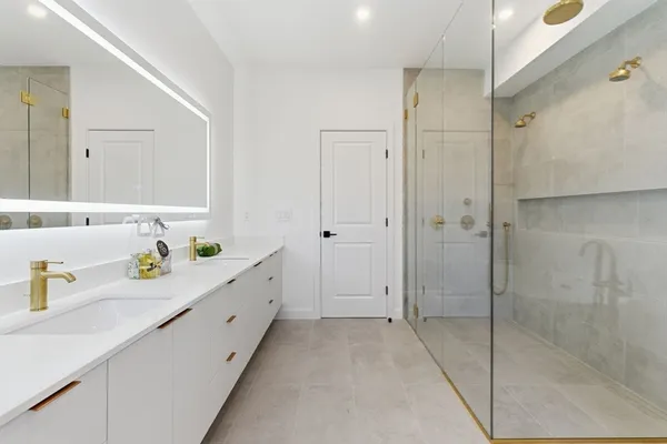 a spacious bathroom with a granite countertop sink mirror and shower