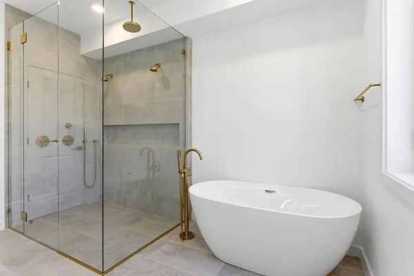 a white bath tub sitting next to a shower