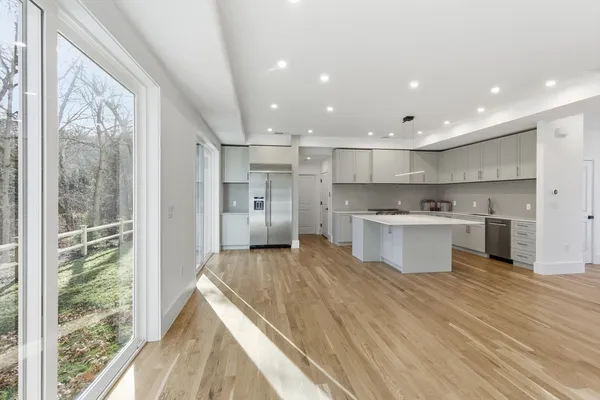 a large kitchen with stainless steel appliances kitchen island a large counter top and a view of living room
