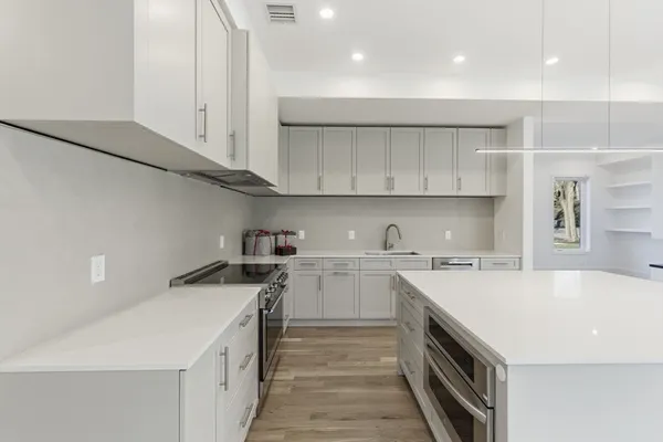 a kitchen with a sink a stove and cabinets