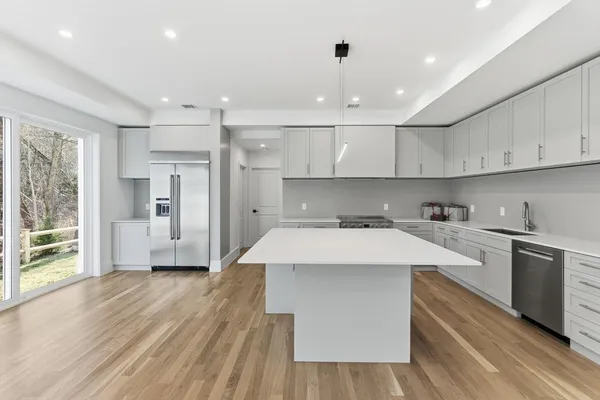 a kitchen with kitchen island a sink stainless steel appliances and cabinets