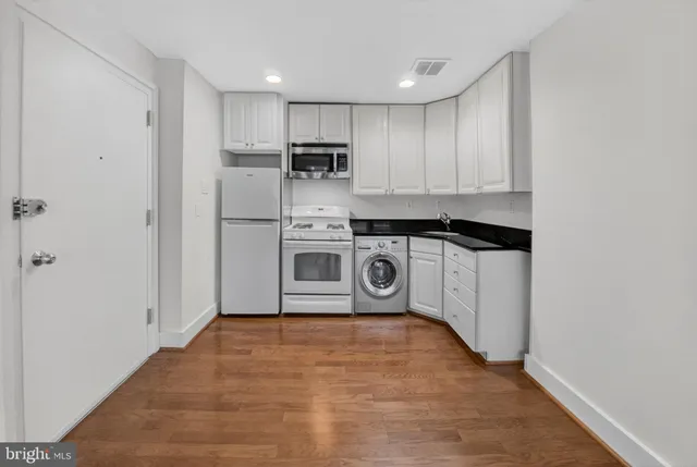 a kitchen with stainless steel appliances a stove top oven and cabinets