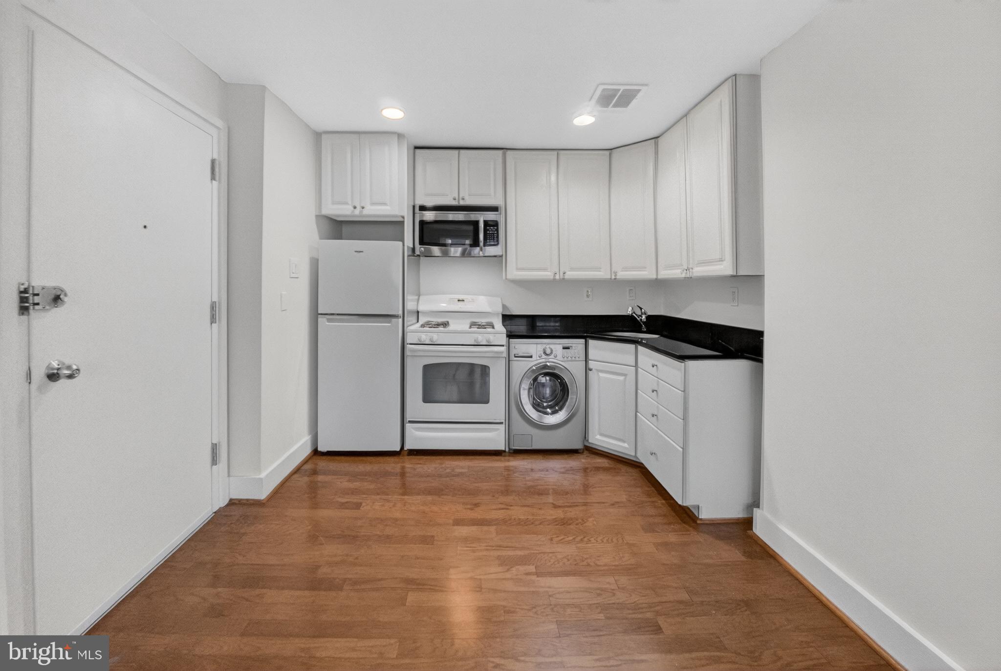 4840 MacArthur Boulevard Northwest, Unit 401 Washington, DC 20007 - Photo 11 of 18 a kitchen with stainless steel appliances a stove top oven and cabinets