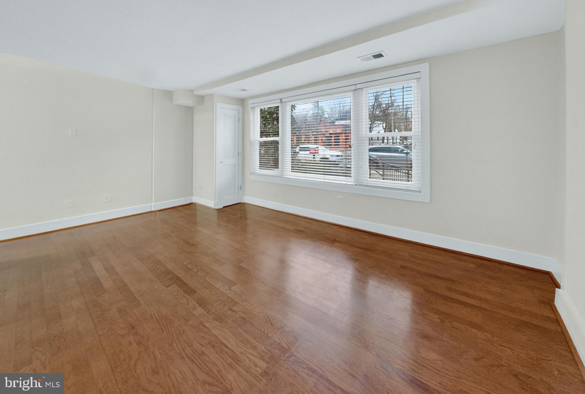 4840 MacArthur Boulevard Northwest, Unit 401 Washington, DC 20007 - Photo 5 of 18 a view of an empty room with wooden floor and a window