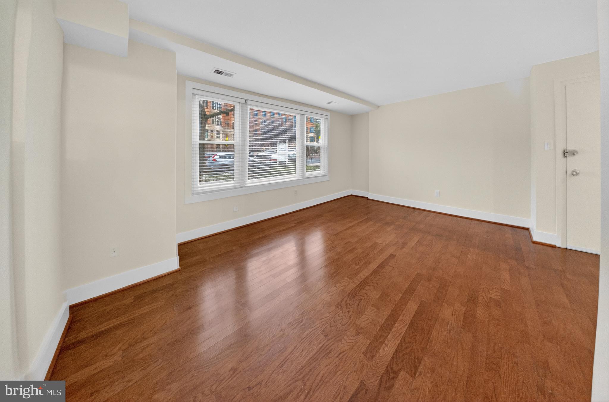 4840 MacArthur Boulevard Northwest, Unit 401 Washington, DC 20007 - Photo 6 of 18 an empty room with wooden floor and windows