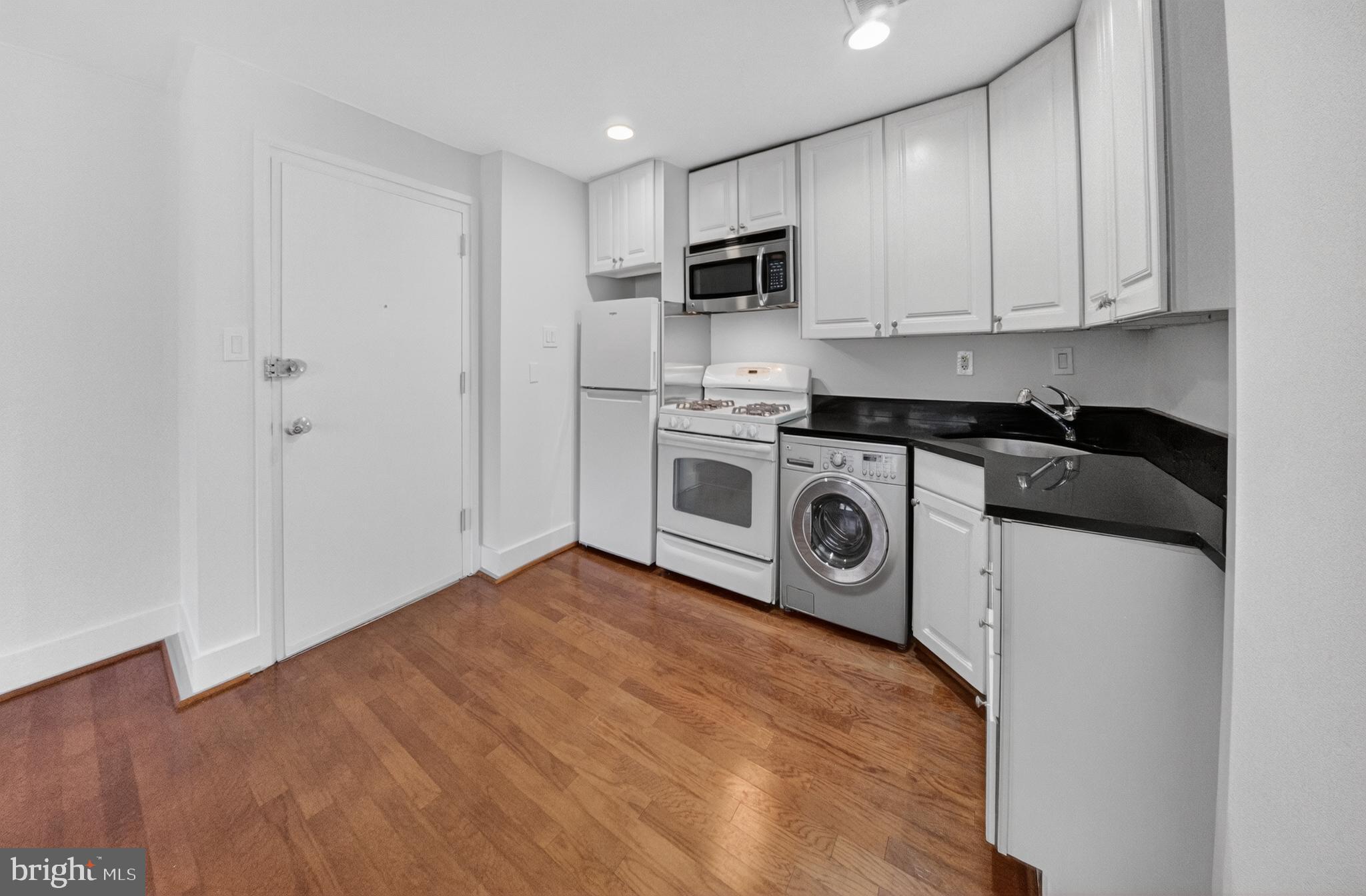 4840 MacArthur Boulevard Northwest, Unit 401 Washington, DC 20007 - Photo 10 of 18 a view of a kitchen with stainless steel appliances granite countertop wooden cabinets and a stove top oven