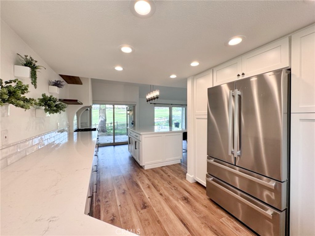38901 Pso Corta Murrieta, CA 92563 - Photo 13 of 51 a kitchen with stainless steel appliances a refrigerator and wooden floor
