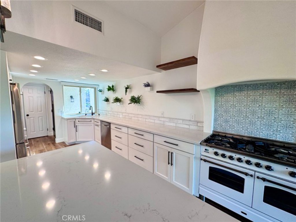 38901 Pso Corta Murrieta, CA 92563 - Photo 16 of 51 a kitchen with stainless steel appliances a stove a sink and a refrigerator