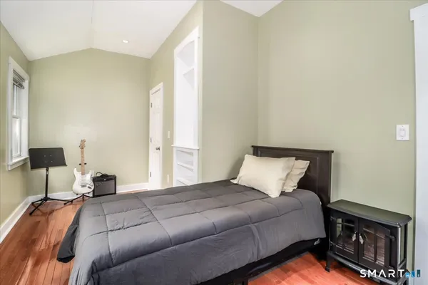 a bedroom with a bed and wooden floor