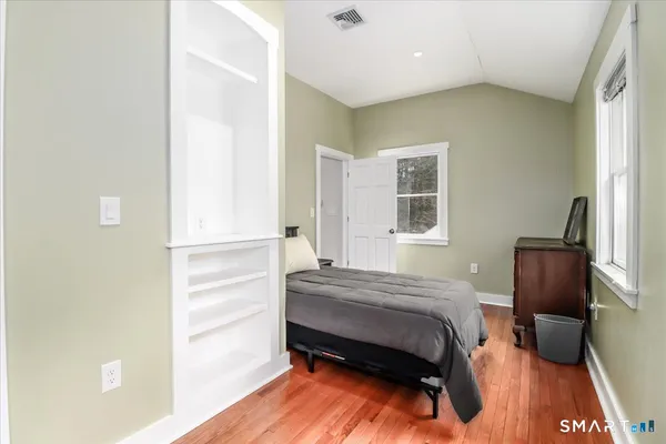 a bedroom with a bed and a refrigerator