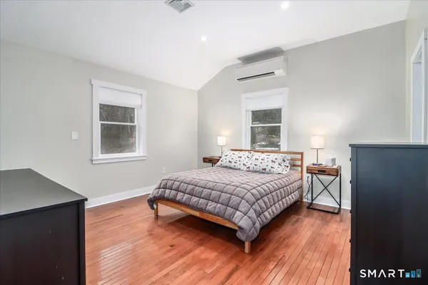 a bedroom with a bed and wooden floor