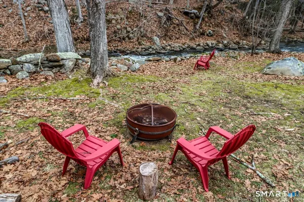 a view of a chairs and fire pit in the backyard