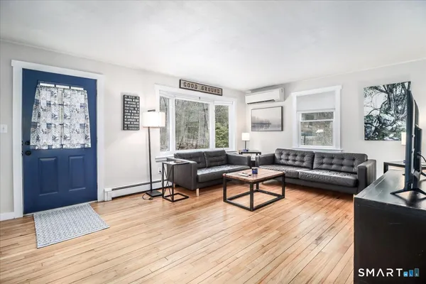 a living room with furniture and a wooden floor