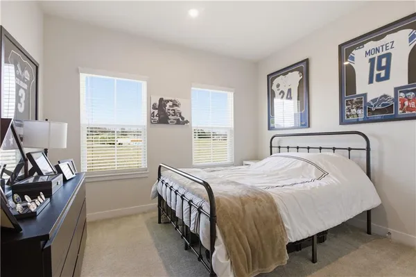 a bedroom with a bed next to a window and a dresser