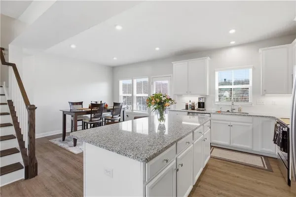 a kitchen with stainless steel appliances granite countertop stove top oven and cabinets