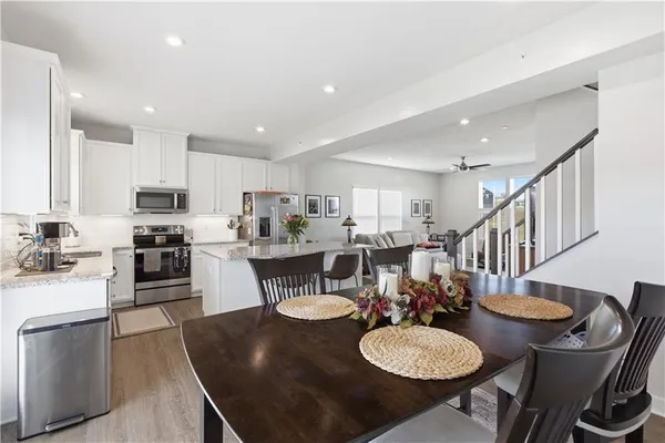 a kitchen with stainless steel appliances granite countertop a stove a sink a dining table and chairs