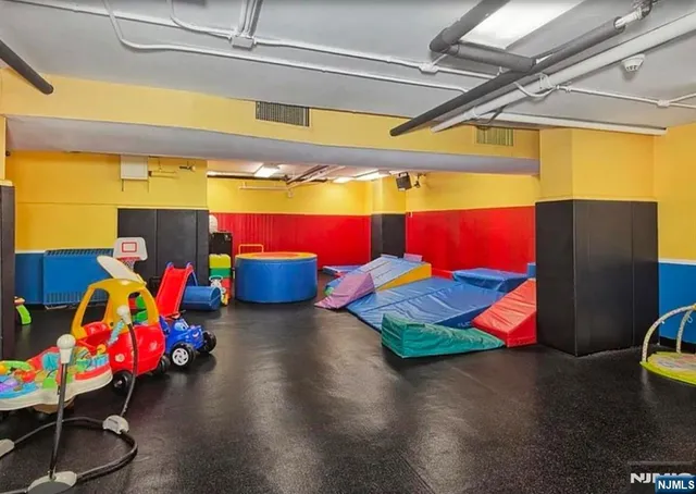 a room with gym equipment and wooden floor