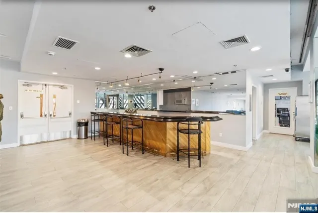 a kitchen with stainless steel appliances kitchen island granite top and refrigerator