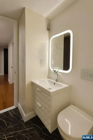 a bathroom with a toilet sink and mirror