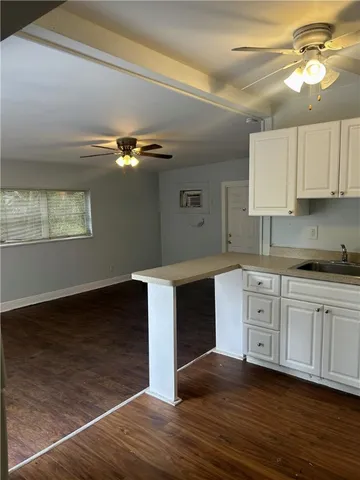 a kitchen with granite countertop a stove cabinets and wooden floor