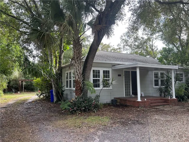a view of a house with backyard and trees