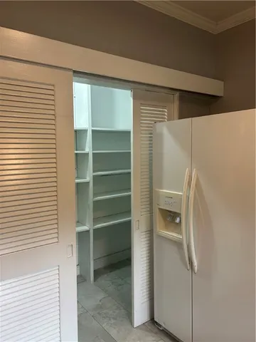 a room with a furniture and a refrigerator