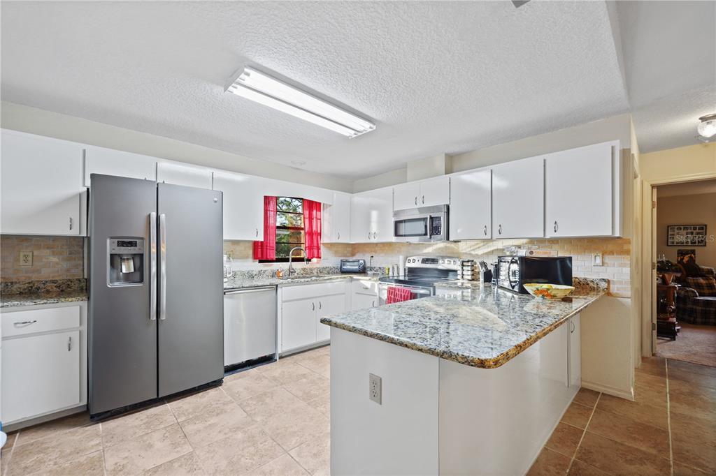 25192 Derringer Road Punta Gorda, FL 33983 - Photo 20 of 39 a kitchen with stainless steel appliances granite countertop a sink stove and refrigerator