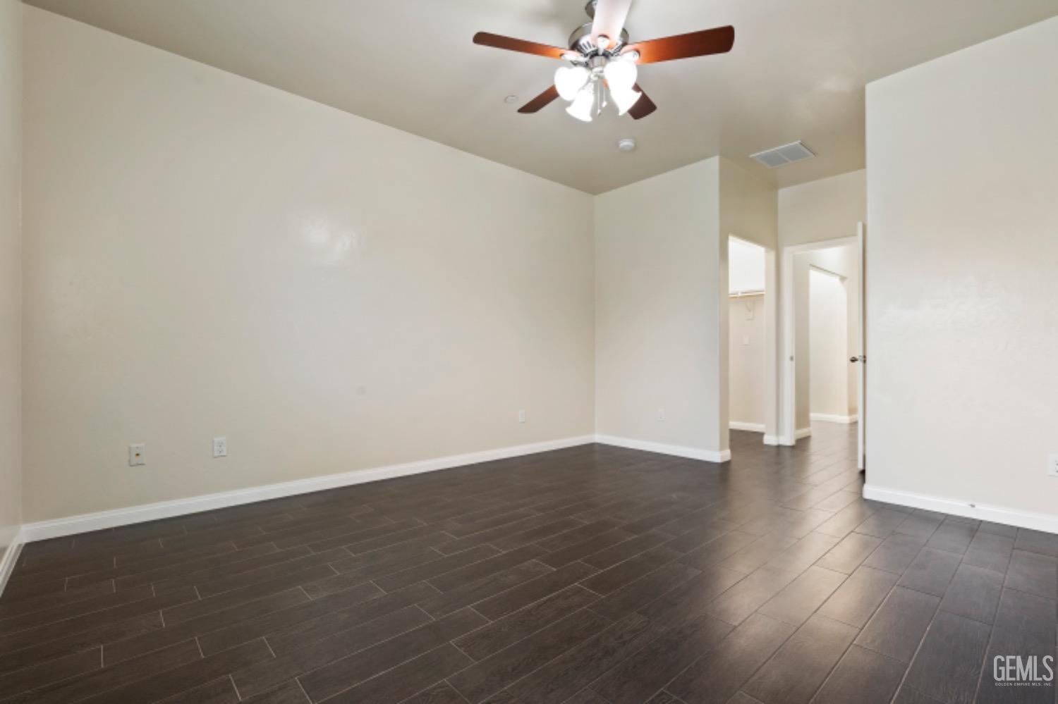 Undisclosed Address Bakersfield, CA 93311 - Photo 19 of 27 an empty room with wooden floor and ceiling fan