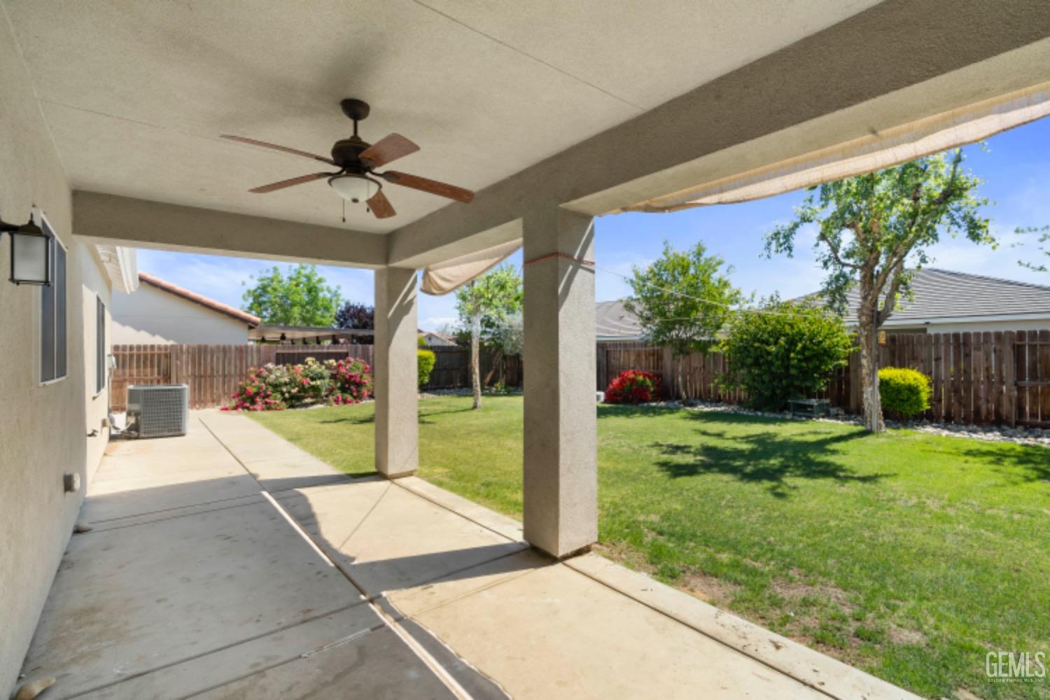 Undisclosed Address Bakersfield, CA 93311 - Photo 22 of 27 a view of a porch with couches and table and chairs under an umbrella